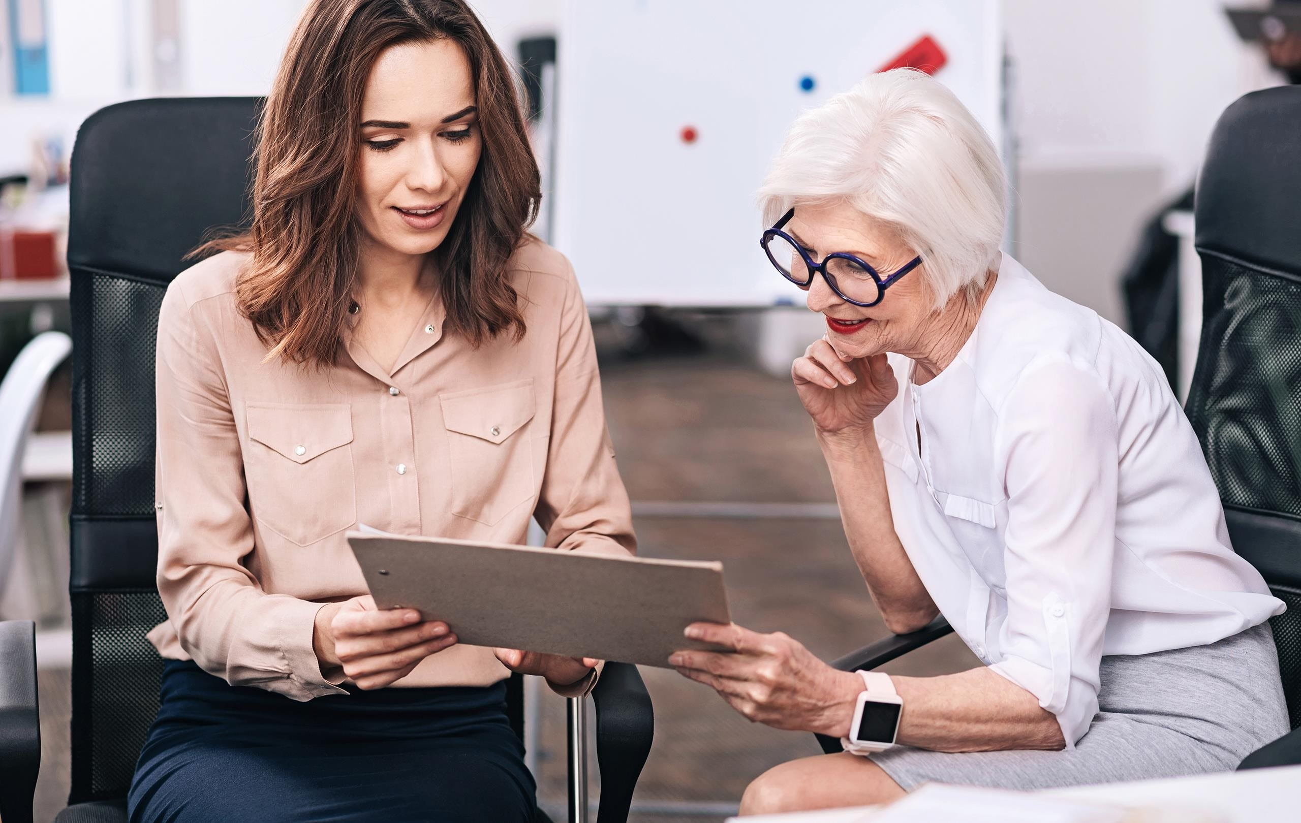 A younger and an older businesswoman discuss the project A younger and an older businesswoman discuss the project